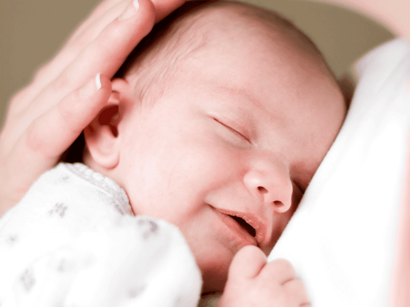Newborn baby cradled in mother's arms